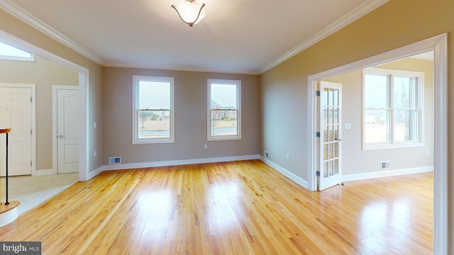 empty room with ornamental molding and light hardwood / wood-style floors