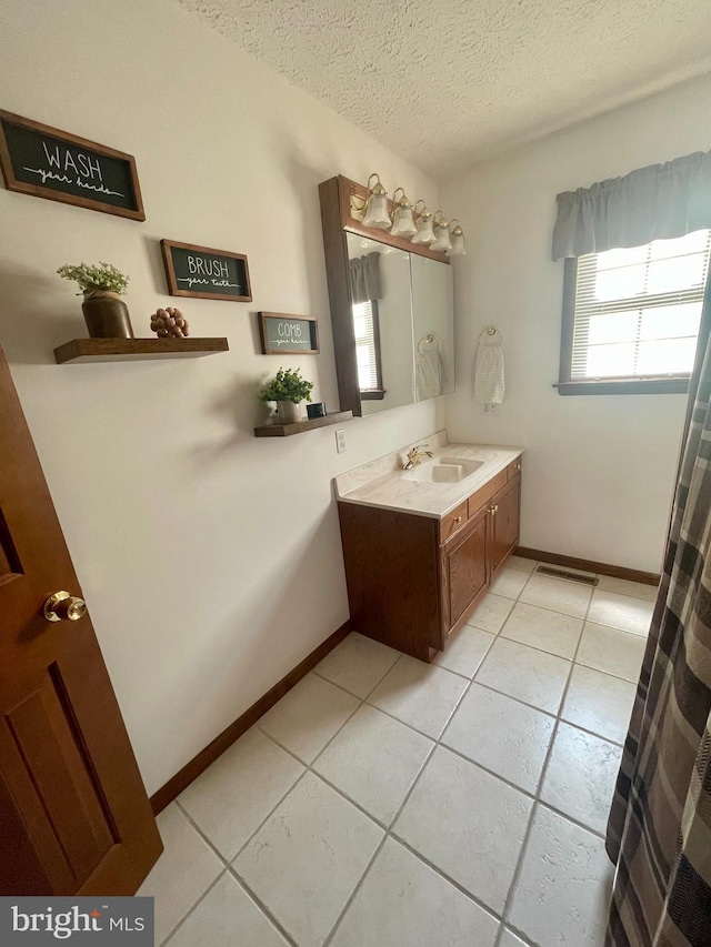 bathroom featuring tile floors, a textured ceiling, and vanity