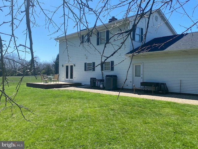 back of house featuring a lawn, central air condition unit, and french doors