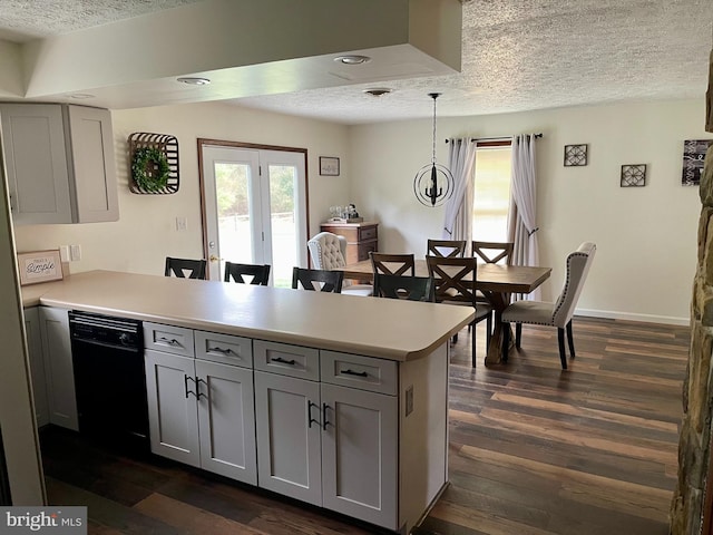 kitchen featuring dark hardwood / wood-style floors, gray cabinetry, pendant lighting, dishwasher, and a textured ceiling