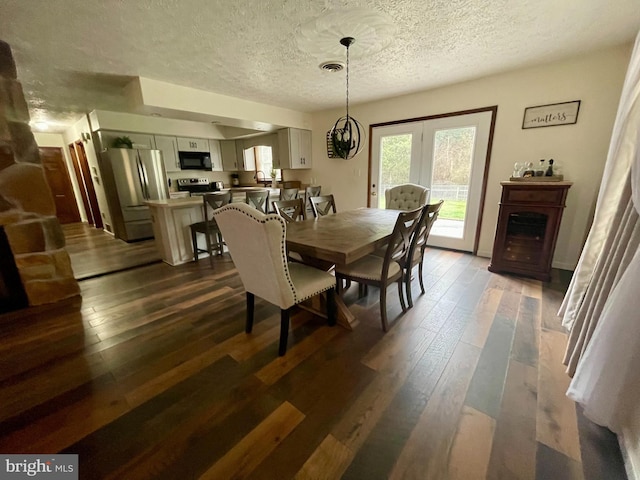 dining area with an inviting chandelier, a textured ceiling, french doors, and dark hardwood / wood-style flooring