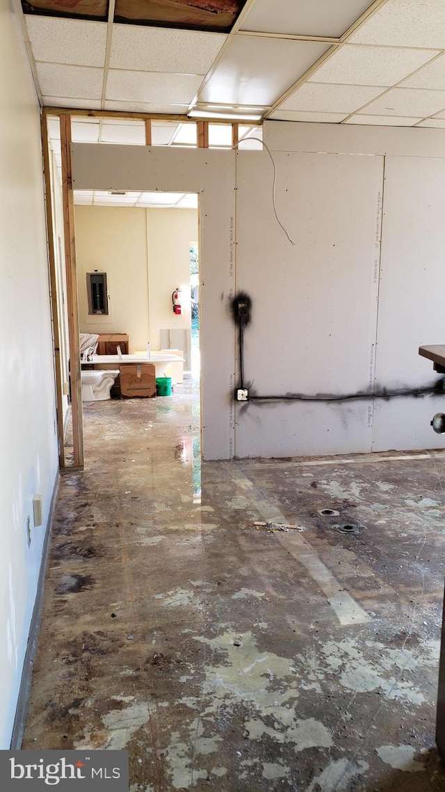 basement with a drop ceiling and dark tile flooring