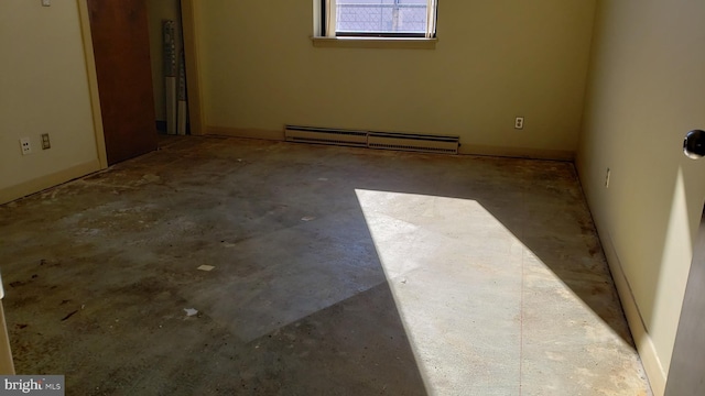 spare room featuring concrete flooring and a baseboard heating unit