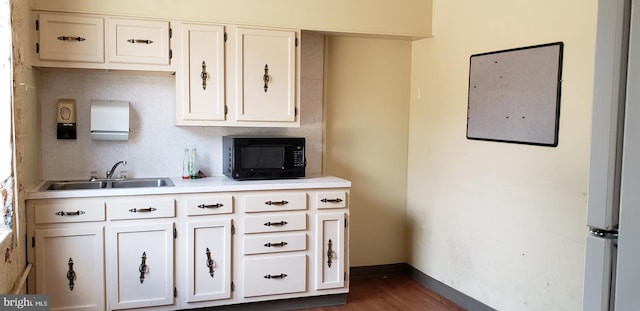 kitchen with white cabinets, dark hardwood / wood-style floors, and sink