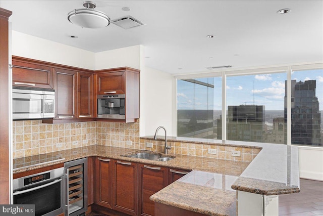 kitchen featuring kitchen peninsula, backsplash, sink, stainless steel appliances, and wine cooler