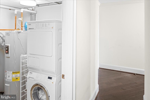 laundry room featuring stacked washing maching and dryer, electric water heater, and dark wood-type flooring