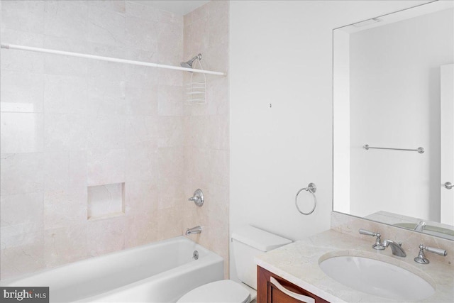 full bathroom featuring tiled shower / bath combo, oversized vanity, and toilet