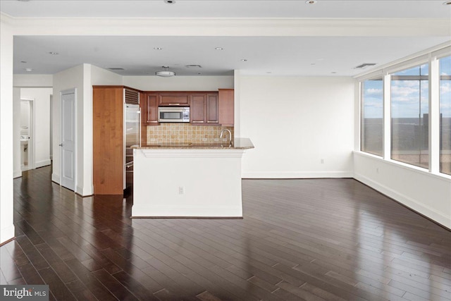 kitchen featuring sink, appliances with stainless steel finishes, backsplash, stone countertops, and dark wood-type flooring