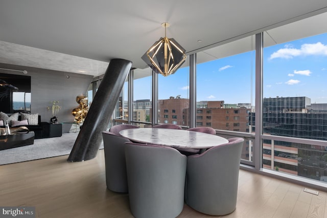 dining area with light hardwood / wood-style floors and expansive windows