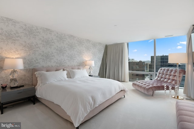 carpeted bedroom with a wall of windows