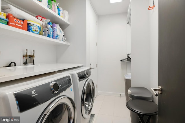 laundry area featuring light tile floors and washing machine and clothes dryer