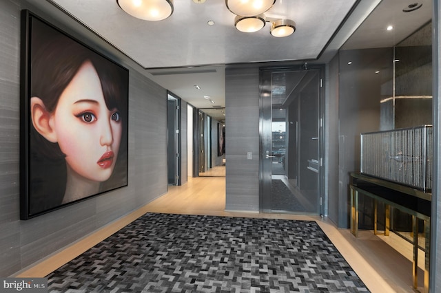 corridor with light hardwood / wood-style flooring and a chandelier