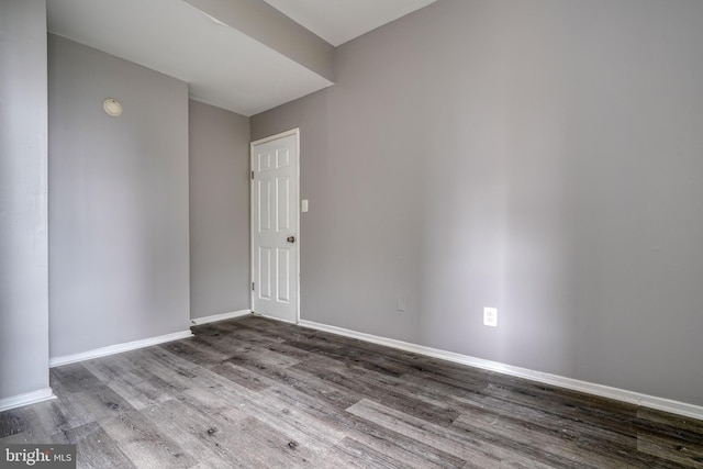 empty room with dark hardwood / wood-style flooring