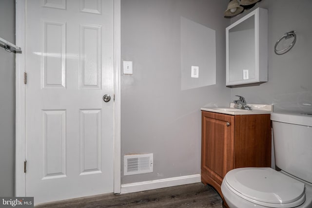 bathroom featuring toilet, hardwood / wood-style floors, and vanity