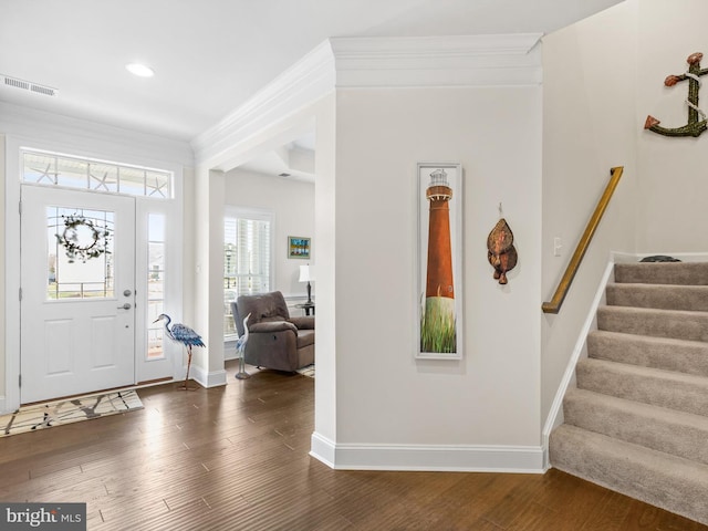 foyer featuring a healthy amount of sunlight, ornamental molding, and dark hardwood / wood-style floors