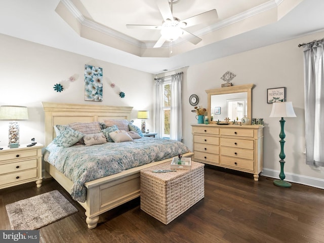 bedroom with ceiling fan, ornamental molding, a raised ceiling, and dark wood-type flooring