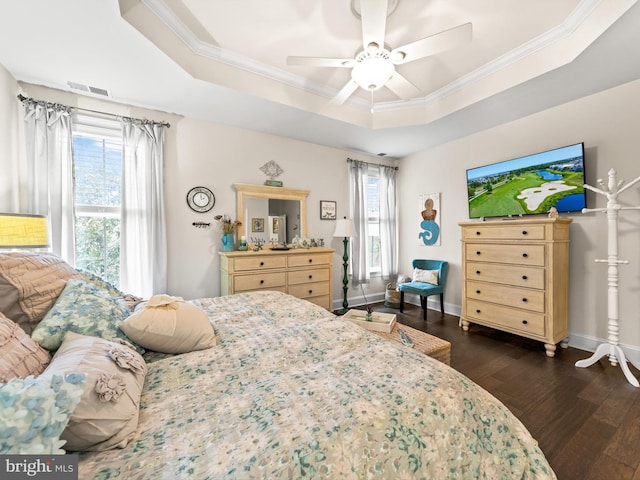 bedroom with ceiling fan, crown molding, dark hardwood / wood-style floors, and a tray ceiling