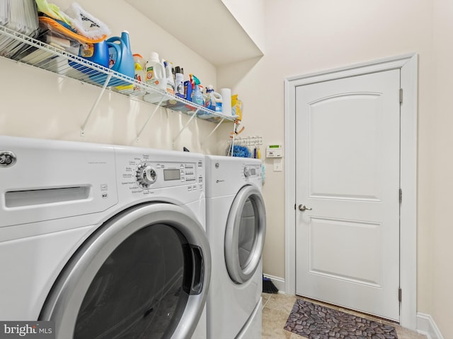 laundry area with light tile floors and washer and clothes dryer