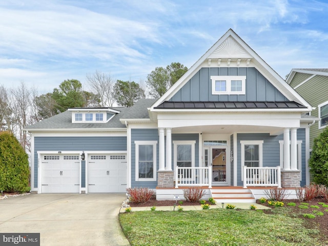 view of front of house with covered porch, a front lawn, and a garage