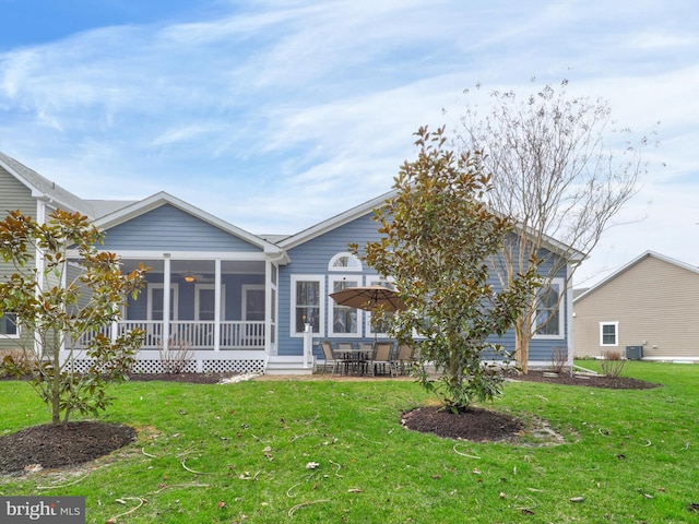 rear view of house featuring central AC, a sunroom, and a lawn