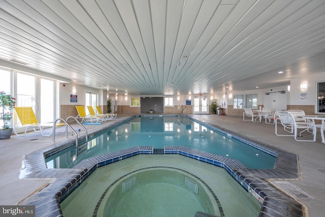 view of pool with an indoor hot tub and a patio area