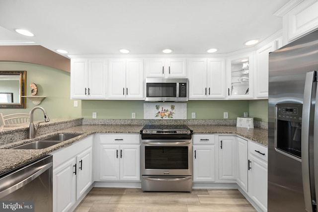 kitchen with appliances with stainless steel finishes, sink, and white cabinets