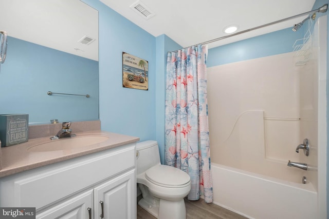 full bathroom with shower / bath combo, toilet, wood-type flooring, and vanity with extensive cabinet space