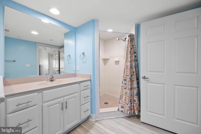 bathroom with curtained shower, vanity, and hardwood / wood-style floors