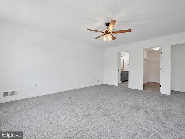 empty room featuring ceiling fan and light carpet