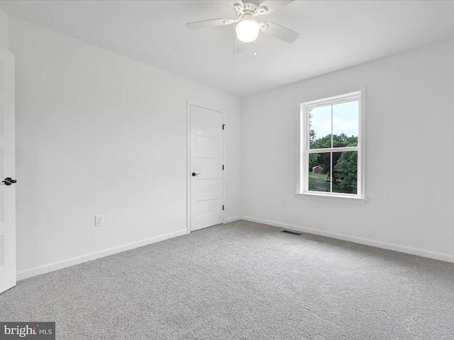 spare room featuring light carpet and ceiling fan