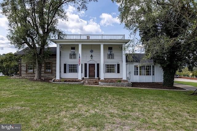 neoclassical / greek revival house featuring a front yard