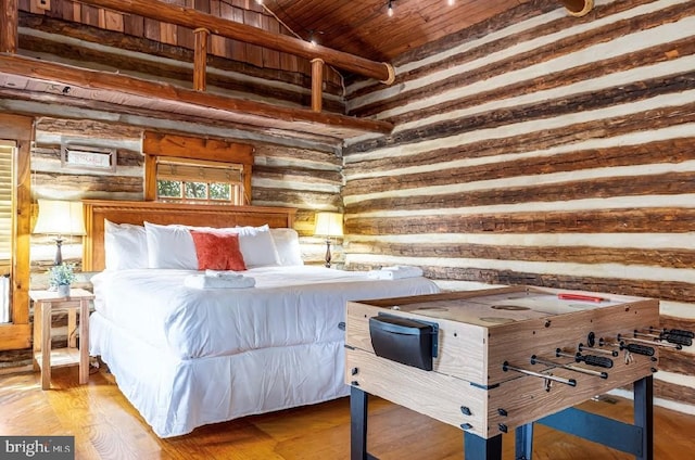 bedroom with log walls, high vaulted ceiling, light wood-type flooring, and beam ceiling