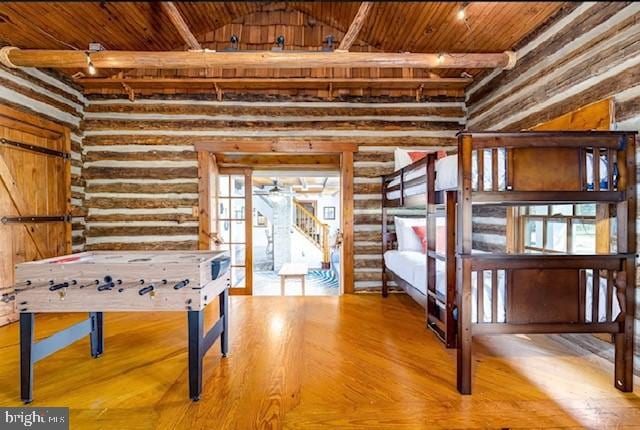 recreation room with log walls, wood ceiling, and light wood-type flooring