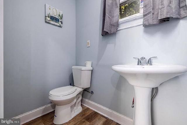 bathroom with toilet and hardwood / wood-style flooring