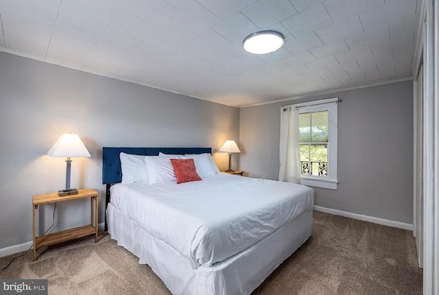 bedroom with dark colored carpet and ornamental molding