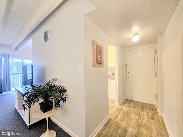 hallway featuring a textured ceiling and light hardwood / wood-style flooring