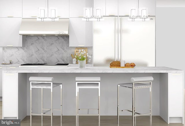 kitchen featuring premium range hood, white fridge, stainless steel gas stovetop, tasteful backsplash, and white cabinets