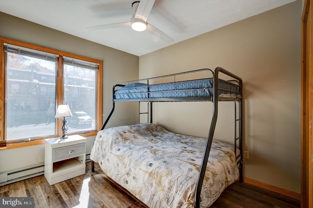 bedroom featuring dark hardwood / wood-style flooring, ceiling fan, and a baseboard radiator