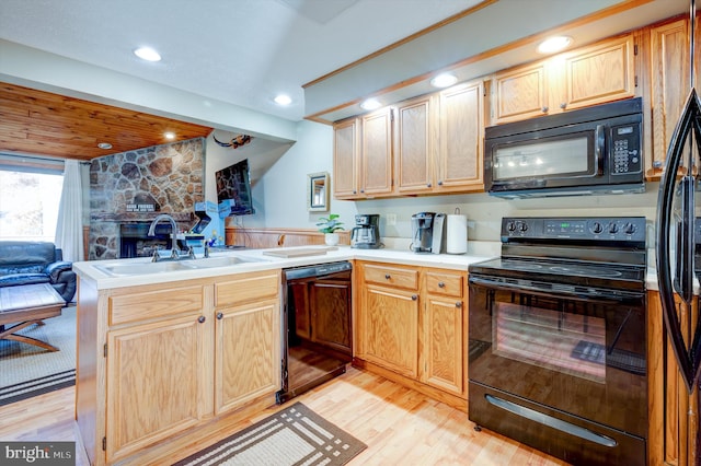 kitchen featuring kitchen peninsula, light wood-type flooring, and black appliances