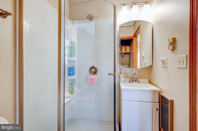 bathroom with a shower with door and vanity with extensive cabinet space