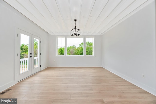 empty room featuring french doors, light wood-type flooring, and a wealth of natural light