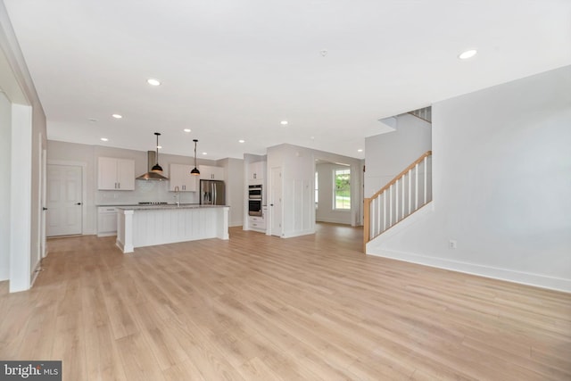 unfurnished living room featuring light hardwood / wood-style floors and sink