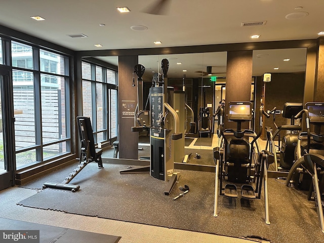 exercise room featuring ceiling fan and dark carpet