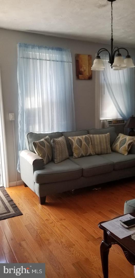 living room with a chandelier and light wood-type flooring