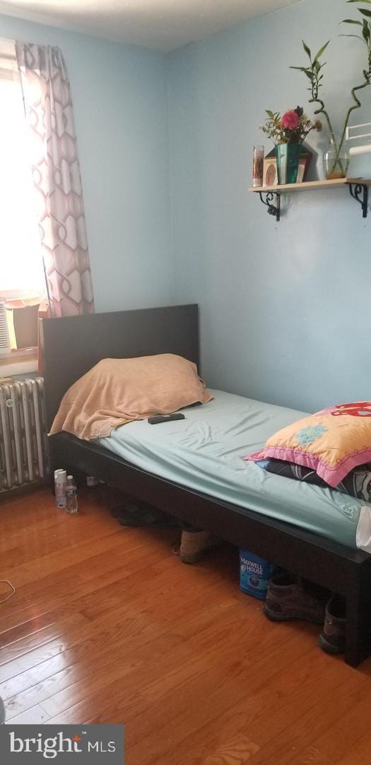 bedroom with hardwood / wood-style floors and radiator