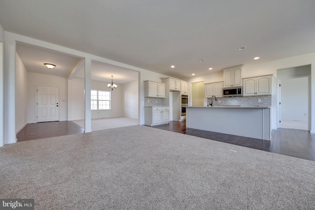 kitchen with hanging light fixtures, dark hardwood / wood-style flooring, a notable chandelier, and white cabinets