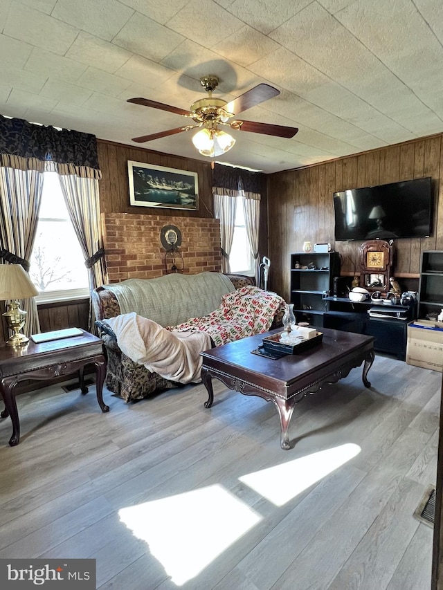 living room featuring ceiling fan, a wealth of natural light, and light wood-type flooring