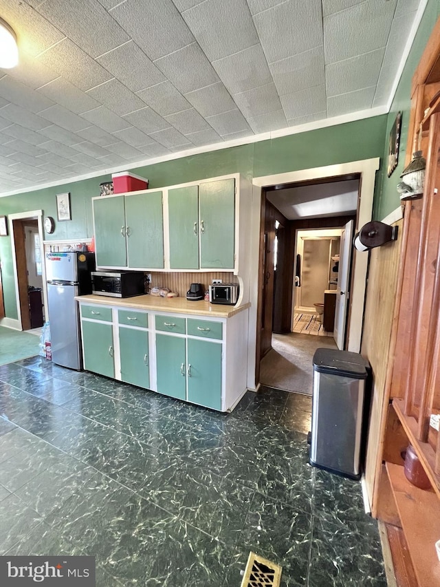 kitchen with stainless steel appliances and dark tile floors