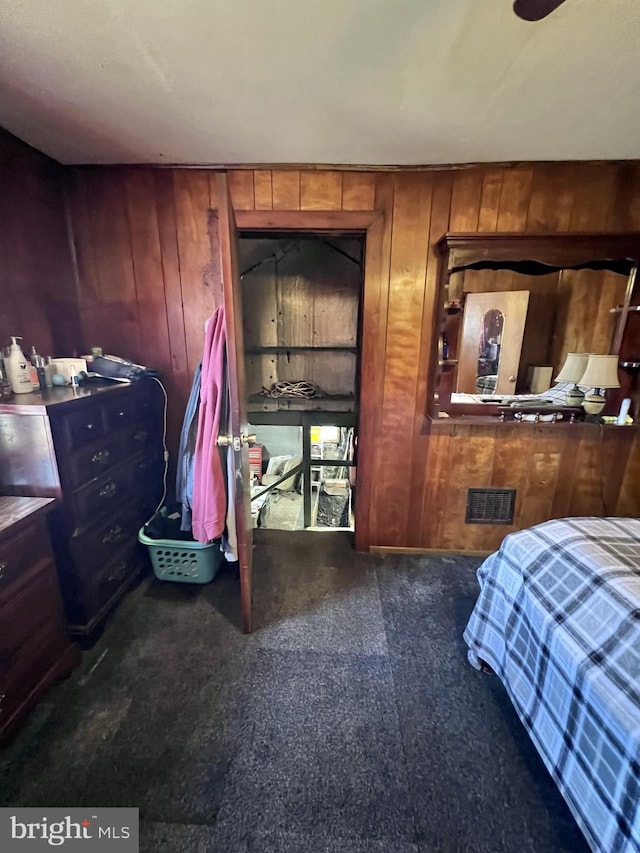 carpeted bedroom with wooden walls