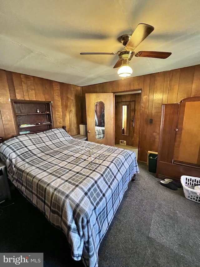 bedroom with wood walls and ceiling fan